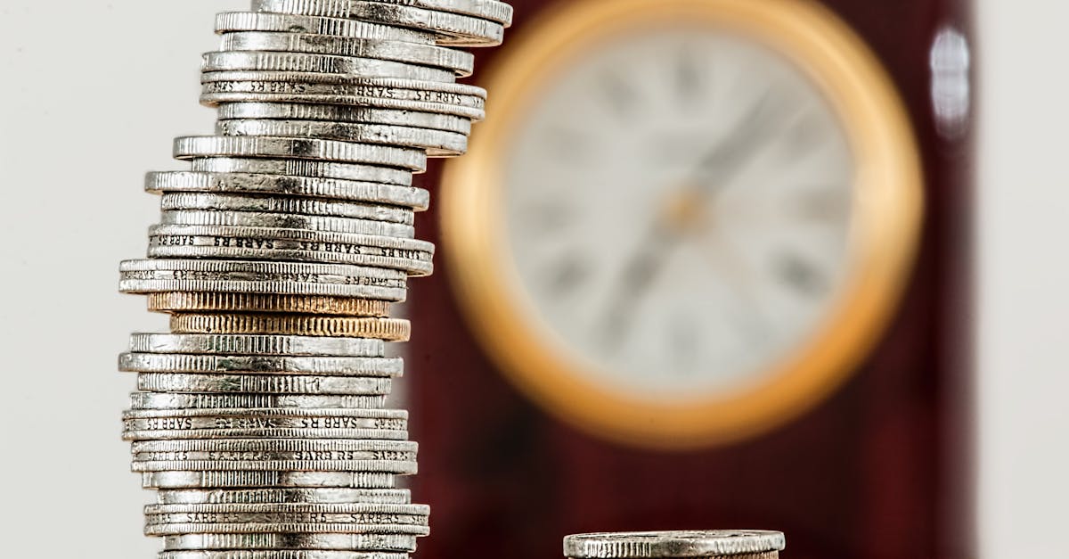 A close-up image of stacked coins with a blurred clock, symbolizing time and money relationship.