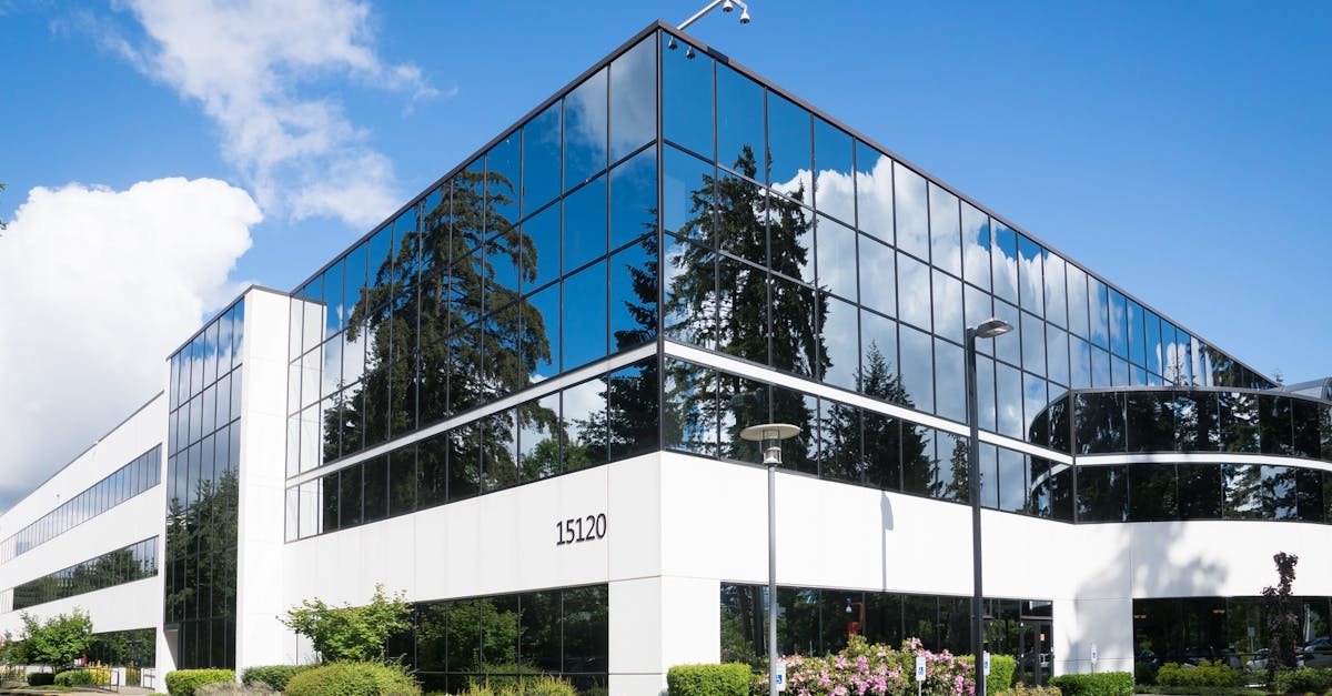 Contemporary office building in Redmond with reflective glass and lush greenery, captured on a sunny day.