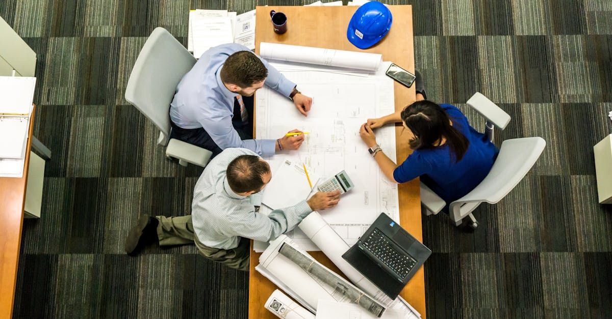 Top view of a team working on construction plans in an office setting.